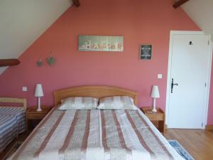 a bedroom with a bed and a red wall at Maison Maton in La Roche-lʼAbeille