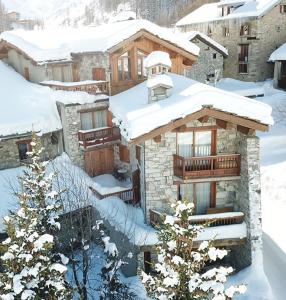 une maison dans la neige avec des toits recouverts de neige dans l'établissement Chalet Barmaz, à Val dʼIsère