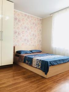トムスクにあるАпартаменты на Савиных 4Аのベッドルーム1室(青いシーツと窓付)
