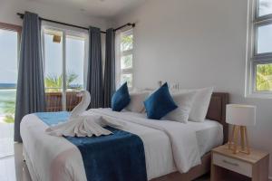 a bedroom with a large bed with a swan on it at Reef Edge Thulusdhoo, Maldives in Thulusdhoo