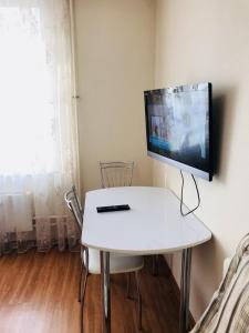 トムスクにあるАпартаменты на Савиных 4Аの白いテーブルの上に座ったテレビ
