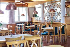 a restaurant with tables and chairs and windows at Pension Pirkdorfer See in Sankt Michael ob Bleiburg