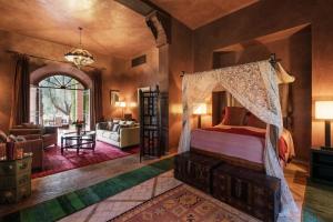 une chambre avec un lit à baldaquin et un salon dans l'établissement Dar Zemora, à Marrakech