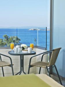 einen Tisch mit Speisen und Getränken auf dem Balkon in der Unterkunft Amarilia Hotel in Athen