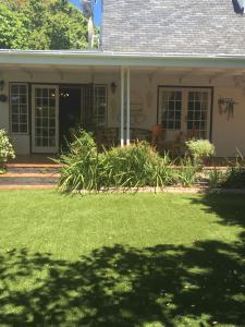 una casa con césped delante en Invergara en Ciudad del Cabo