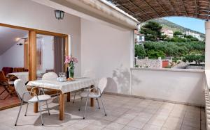 comedor con mesa, sillas y ventana en Apartmani Dolac, en Ivan Dolac