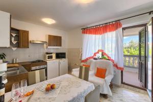 a kitchen with a table and a dining room at Apartman D&D, Dvorine 63 in Banjole