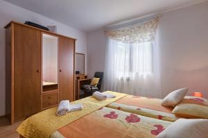 a bedroom with a large bed with towels on it at Apartman D&D, Dvorine 63 in Banjole