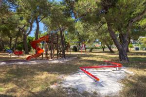 a park with a playground with a red slide at Apartman D&D, Dvorine 63 in Banjole