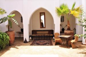salon z kanapą, stołem i krzesłami w obiekcie Riad Miski w Marakeszu