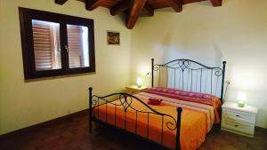um quarto com uma cama e uma janela em Borgo Bellavista Badesi em Badesi