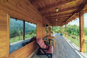veranda di una baita di tronchi con sedie e tavolo di Chalet Tara a Mojkovac
