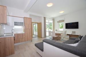 kuchnia i salon z kanapą i stołem w obiekcie Apartment Anića Kuk w mieście Starigrad-Paklenica