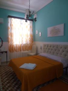 sypialnia z łóżkiem z pomarańczowym kocem w obiekcie B&B Mariupol w Trapani