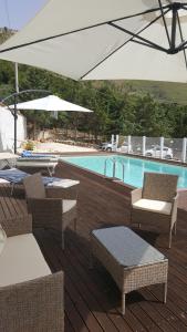 eine Terrasse mit Stühlen, einem Sonnenschirm und einem Pool in der Unterkunft Villetta Delizia in Scopello