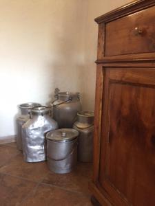 een groep zilveren potten en een houten kast bij Bed & Breakfast Col Mazzet in Belluno