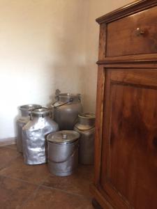 eine Gruppe silberner Töpfe und ein Holzschrank in der Unterkunft Bed & Breakfast Col Mazzet in Belluno