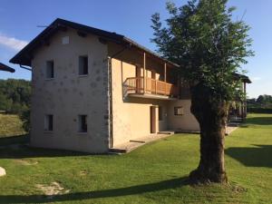 a large building with a balcony and a tree at Bed & Breakfast Col Mazzet in Belluno