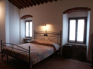 a bedroom with a bed in a room with windows at Galleria Ars Apua in Carrara