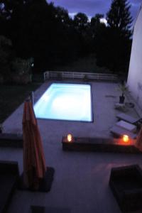 a swimming pool at night with a lit up screen at La Houblonniere in Beire-le-Châtel