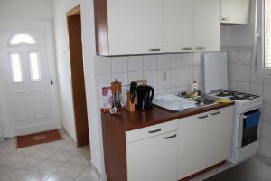 a kitchen with white cabinets and a counter top at Apartments Alma in Orebić