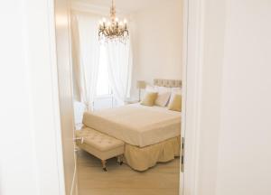 a bedroom with a bed and a chandelier at Palazzo Spasiano rooms - SORRENTO CENTER in Sorrento