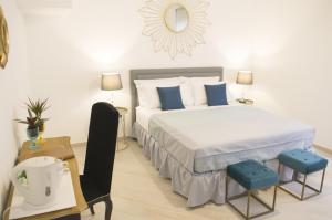 a bedroom with a bed and two blue chairs at Palazzo Spasiano rooms - SORRENTO CENTER in Sorrento