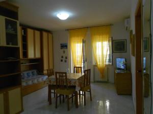 ein Wohnzimmer mit einem Esstisch und Stühlen in der Unterkunft Casa Magnolia in Gaeta