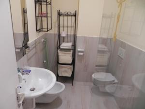 bagno con lavandino bianco e servizi igienici di Casa Vacanze Monachy a Merano