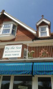 a building with a sign for a bed and breakfast at By The Sea Bed and Breakfast in Eastbourne
