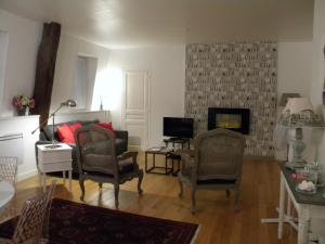 a living room with two chairs and a fireplace at Les chanceliers Duplex in Beaune