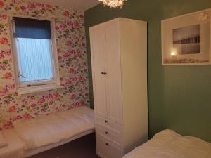 una camera da letto con un letto, un armadio e una finestra di De Kapershut a Hollum