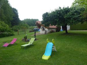 een glijbaan in een tuin met stoelen en een huis bij Pause Couffy in Couffy