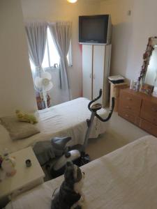 a bedroom with two beds and a desk with a vacuum at los troncos 2 in Puerto Madryn