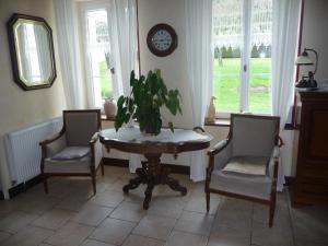 een eetkamer met een tafel en twee stoelen en een plant bij Pause Couffy in Couffy