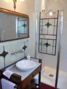 a bathroom with a sink and a shower with a mirror at La Tourelle 22 in Quintin