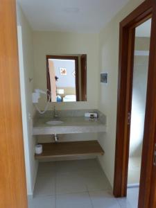 une salle de bain avec un lavabo et un miroir dans l'établissement Aldeia das Águas Park Resort, à Barra do Piraí