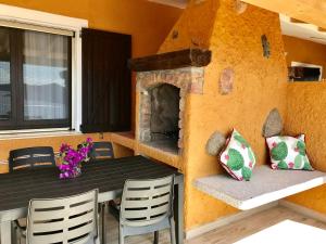 a dining room with a table and a fireplace at Case Vacanza Mare Nostrum in Torre delle Stelle