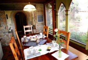 a dining room with a wooden table with flowers on it at La Tourelle 22 in Quintin