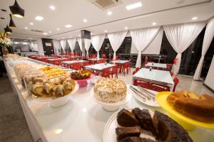 a buffet line with different types of bread and pastries at Hiber Hotel - Acesso a Chapecó in Chapecó