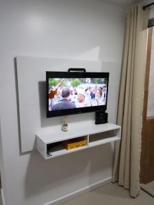 TV de pantalla plana en la pared en Condominio Galeao, en Florianópolis
