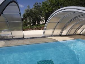 una gran piscina con una estructura abovedada en Chez Gerard, en Champigneulles