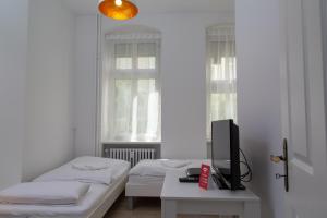 ベルリンにあるPandoras homeのベッドルーム1室(ベッド2台、テーブル上のテレビ付)