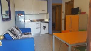 cocina con sofá, mesa y nevera en Immobiliare Al Ponte, en Cavallino-Treporti