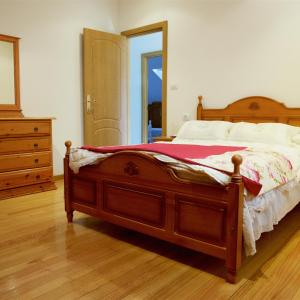 a bedroom with a bed with a dresser and a mirror at Vivienda de uso turístico Eido de Roque in Mondariz