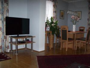 ein Wohnzimmer mit einem TV auf dem Tisch und ein Esszimmer in der Unterkunft Riedl Gästewohnung in Klagenfurt am Wörthersee