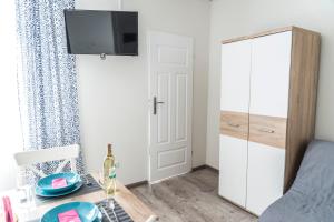 a small bedroom with a table and a tv on a wall at Apartamenty Mewa in Międzyzdroje