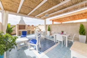 een patio met tafels en stoelen en een open haard bij Cielo e Mare in Marina di Mancaversa