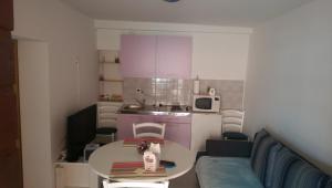 a small room with a table and a kitchen at Ani in Povljana +52 photos