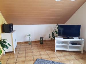 ein Wohnzimmer mit einem Flachbild-TV und einem Tisch in der Unterkunft Ferienwohnung Hedi in Mertloch